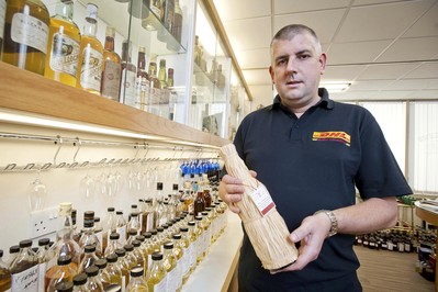 'Brian Johnstone, DHL's Air Freight Export Manager for Wine & Spirits, holding one of the special edition, recreated whisky bottles in the master blenders room at Whyte & Mackay'